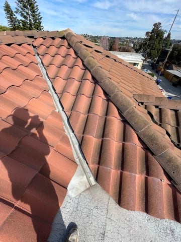 Wide view of a metal valley running between two red tile roof planes